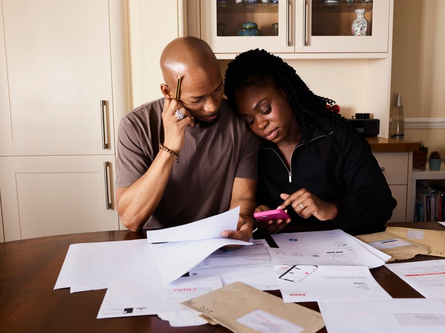 A couple going through bills at the kitchen table